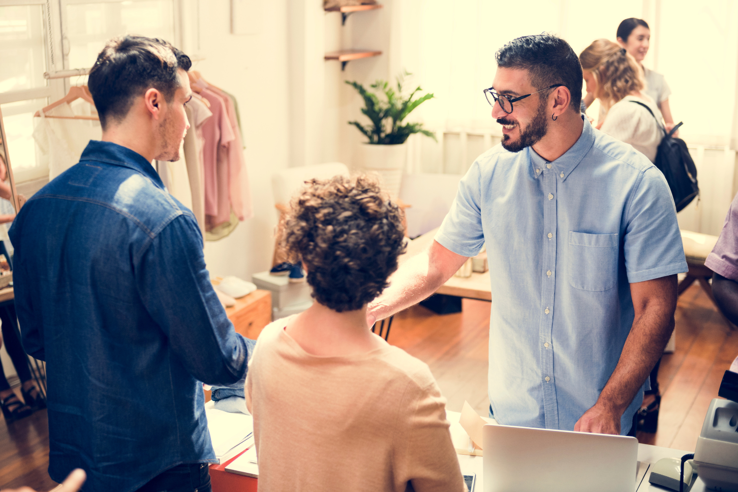 retail team training session in bright homeware or lifestyle store, manager demonstrating customer service standards, professional candid style