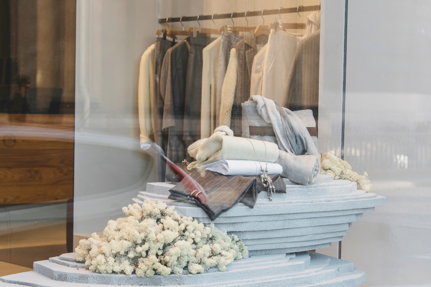 visual merchandising team styling beauty or fragrance display in department store, polished retail presentation, bright clean premium setting